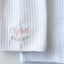 White textured blanket with embroidered name 'Elizabeth' and floral design on a light gray background
