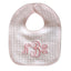Pink baby bib with embroidered initials on a light gray background