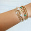 Gold bracelets with pearls and charms on a wrist against a white background - {Pre-Order} Limited Edition egives to Camp Mystic Bracelet - Houston, Texas 